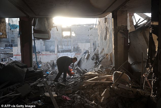 A man searches for his belongings amid the rubble of a destroyed building after an Israeli airstrike in Gaza on January 6