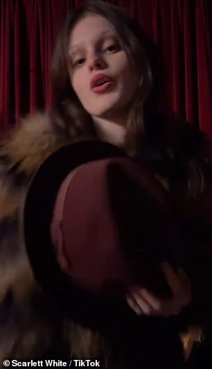 Channeling her parents' sense of style, she was wrapped in a striped faux fur coat and a cheerful burgundy hat, sharpening her features with deep red lipstick.