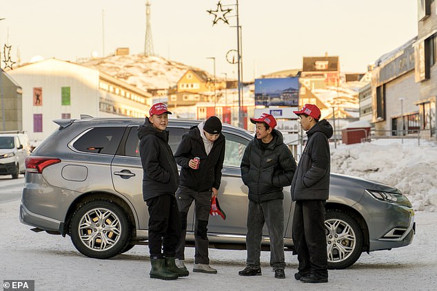 Residents of Nuuk, Greenland, wear red Make America Great Again hats as they stand outside Hotel Hans Egede during Don Jr.'s visit. there Tuesday