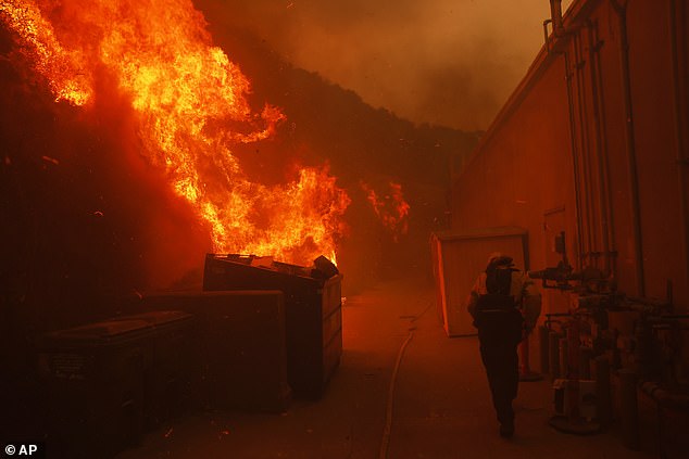 A firefighter protects a structure from the advance in California