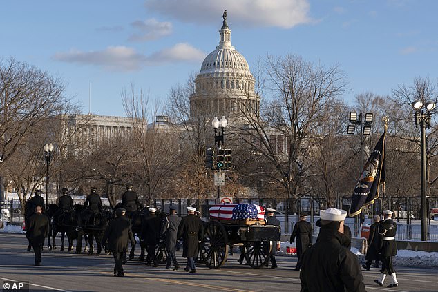 The flag-draped coffin makes its way to Capitol Hill at Constitution Avenue