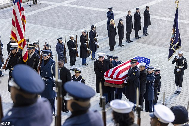 Former President Carter's casket is carried up the steps of the US Capitol