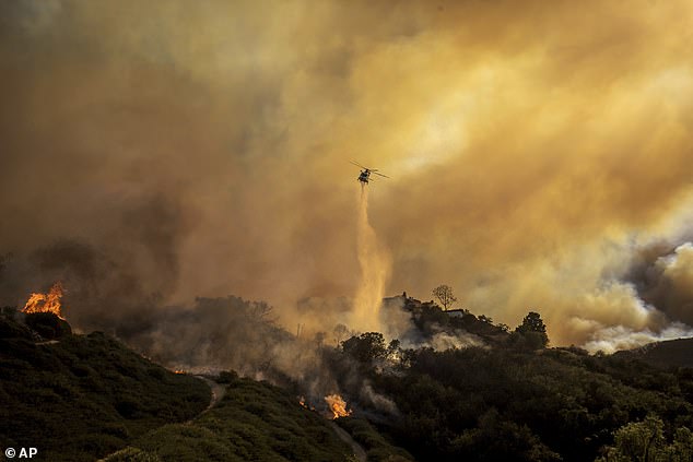 Pacific Palisades Fire Department drops water from a helicopter as an intense blaze destroyed the upscale California neighborhood Tuesday