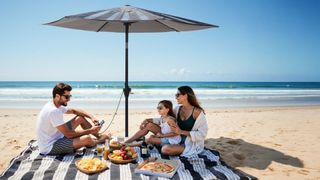 Family relaxing on the beach under the Anker SOLIX sun parasol