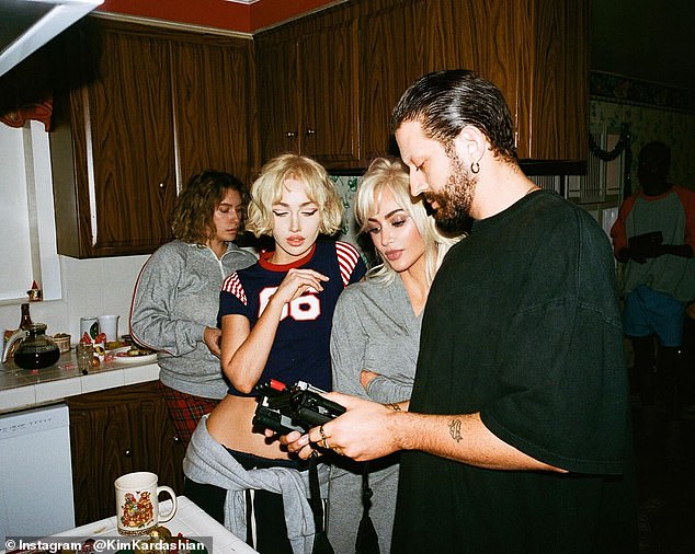 The disturbing music video was directed by Nadia Lee Cohen (second from left) and Charlie Denis (R), who were both pictured at a conference with Kim as they appeared to watch some footage in the home's kitchen.