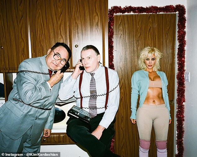 In the old-fashioned kitchen, Kim posed against a door next to male actors, apparently dressed as businessmen, who spoke on landline phones with the cords wrapped around their bodies.