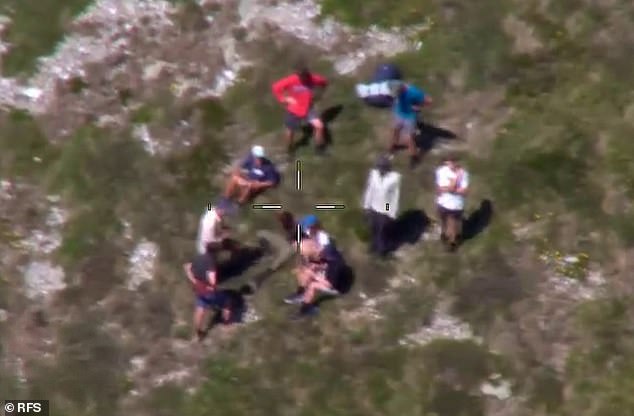 Mr Nazari was found by hikers who were not part of the search party (in the photo the hikers are sitting while Mr Nazari waits to be winched up)