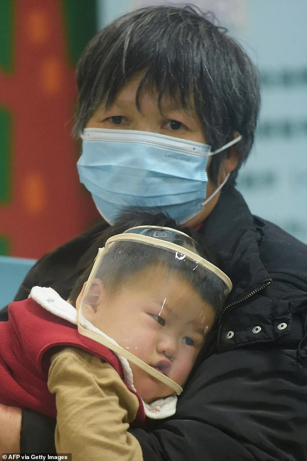 Pictured, an adult and a child wait to be seen by medical staff at the pediatric ward of a hospital in Hangzhou, eastern China on January 6