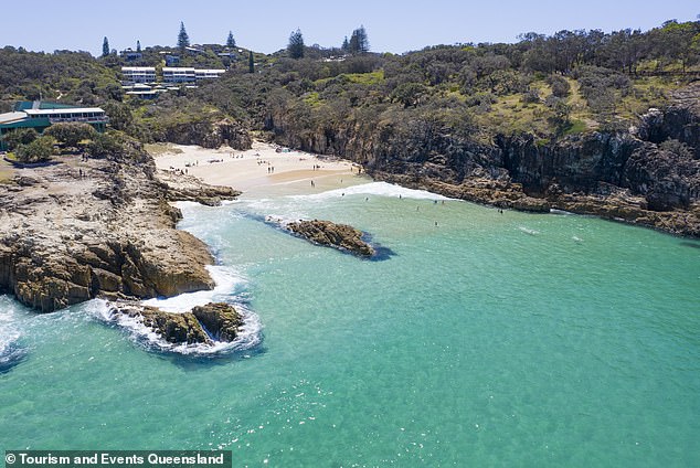 Tucked away on Minjerribah (North Stradbroke Island) is South Gorge Beach, a breathtaking expanse of sand surrounded by towering cliffs on either side