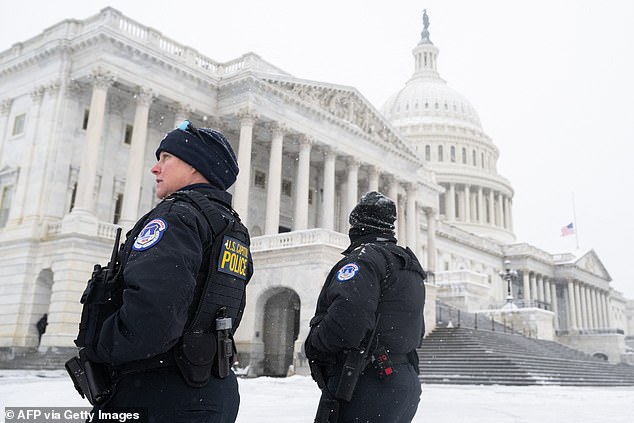 Capitol Police officers stand guard outside the Capitol as snow falls ahead of a joint session of Congress to certify the results of the 2024 presidential election on January 6, 2025 in Washington, DC