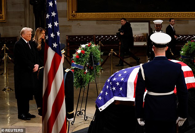 The incoming first couple walked into the Capitol Rotunda and stood for a moment of silence at his casket