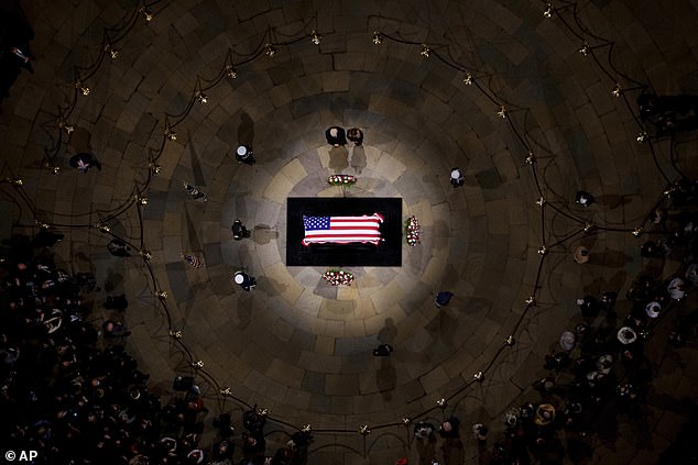 Donald and Melania stand by Jimmy Carter's flag-draped casket for a moment of reflection in the Capitol Rotunda