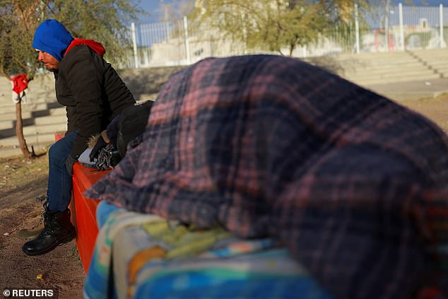 Francisco Lopez, a Mexican migrant trying to reach the United States, sits in a plaza during a day of low temperatures in Ciudad Juarez, Mexico