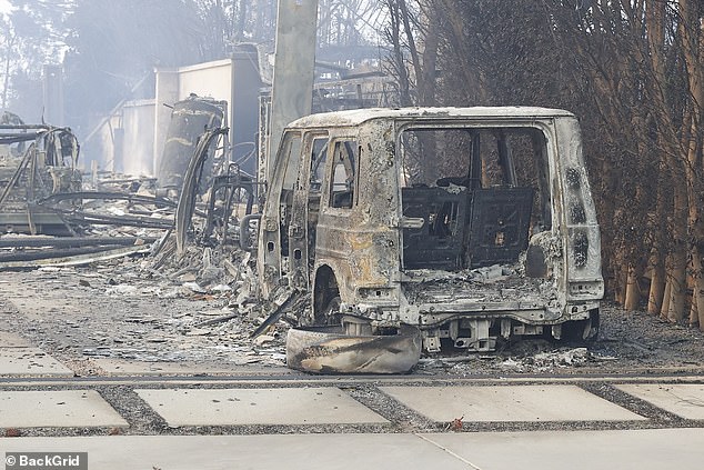 A charred car was found parked in the home's driveway, covered in ash and debris