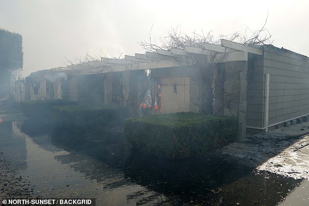 Although many of the walls appear to be still standing, they have been blackened by the flames, while many parts of the house are still on fire.