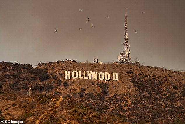 The Hollywood Sign is seen Wednesday with smoke from multiple wildfires in LA