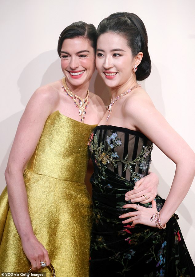 Hathaway put her arm around the Chinese-American 37-year-old for a smiley face at the 