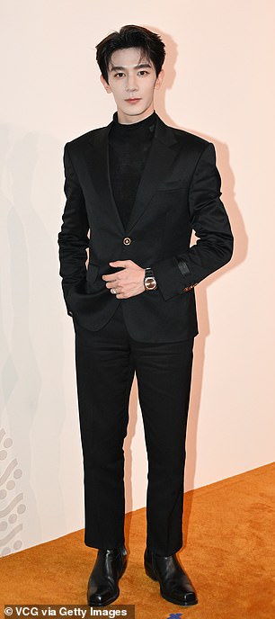 Blossom actor ZhiGuang Xia wore a black suit, patent leather shoes and a wristwatch