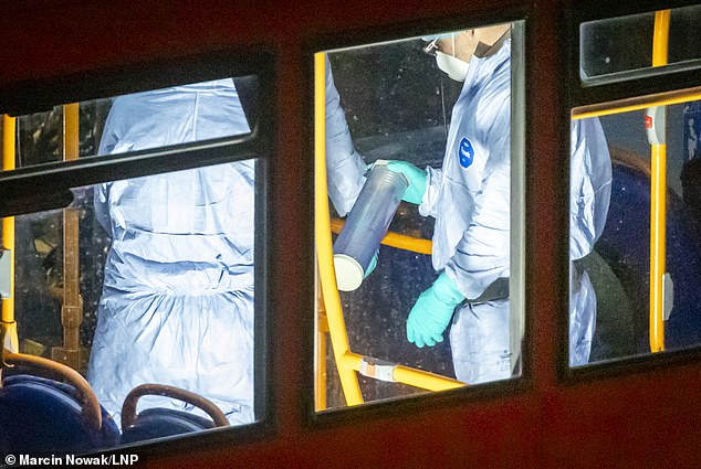 A forensics officer is seen on board the bus holding a weapons tube used to collect evidence - January 7, 2025