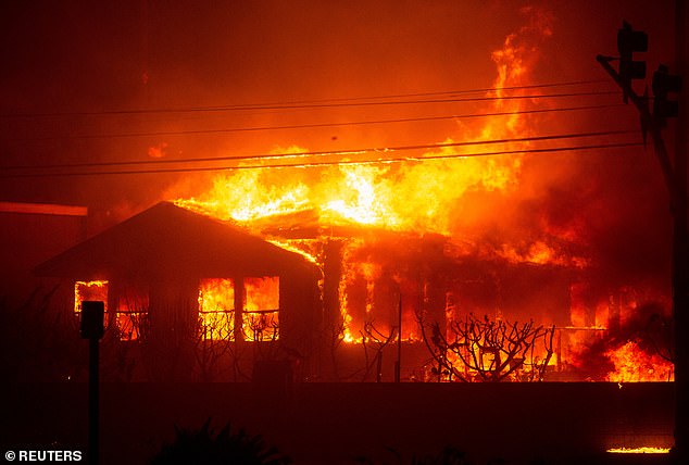 Fire engulfs a structure as the Palisades Fire burns during a storm on the west side of Los Angeles on January 7