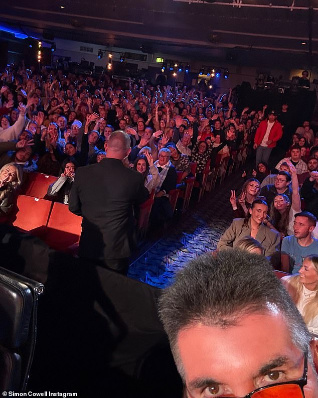 Once inside the theater, Simon took a selfie with the cheerful audience waving at the camera