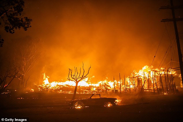 Flames from the Palisades Fire burned a car and homes in Los Angeles yesterday