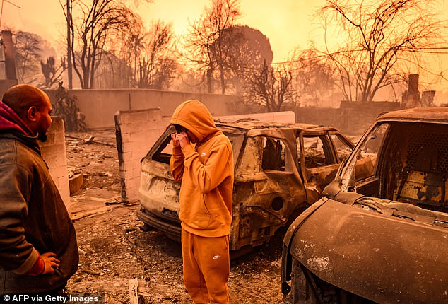 Lebron Jones (center) wipes his eyes as he looks at his burned home during the Eaton fire in the Altadena area of ​​Los Angeles County, California on January 8, 2025