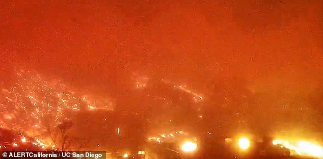 A webcam screenshot at 11:31 p.m. shows parts of LA completely engulfed in flames