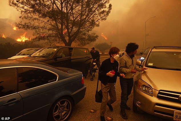 People fled the advancing Palisades Fire by car and on foot in Los Angeles yesterday