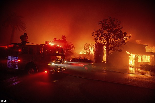 Firefighters battled the blaze yesterday as it burned buildings in the Pacific Palisades area