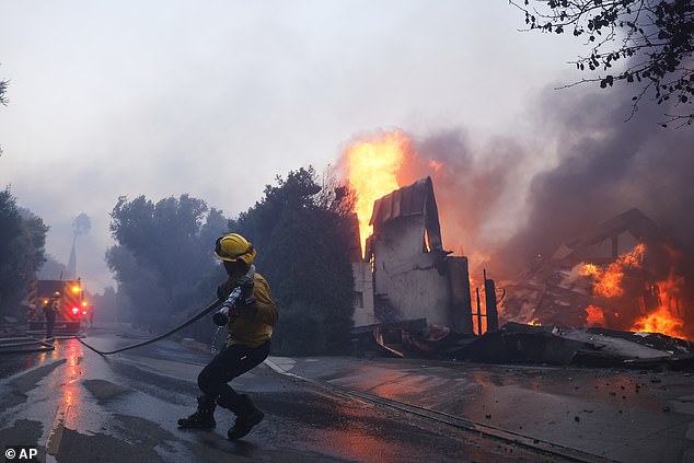 Firefighters battled the fire yesterday as it burned buildings in the Pacific Palisades area