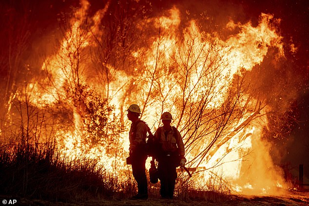 Mandatory evacuation orders are in effect as firefighters drop water bombs from the sky in an attempt to contain the blaze, which is being fanned by strong Santa Ana winds.