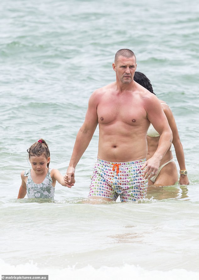 Kris seemed to be very much in doting dad mode as he happily played with Mila and Frankie, the couple's daughter, on the sand and in the sea