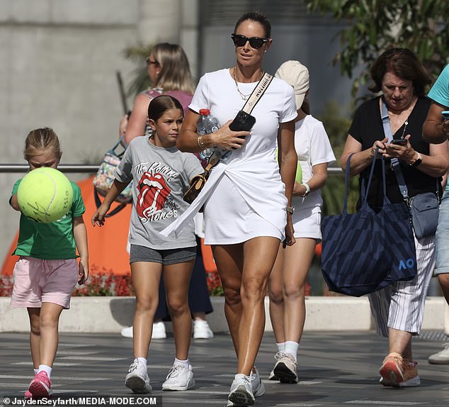 Cricket legend Dave Warner's wife put on a very leggy show in a flirty mini tennis dress with wrap-around waist detail