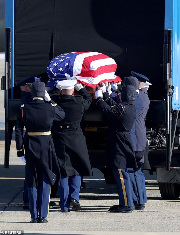 Former US President Jimmy Carter's flag-draped casket is loaded onto Special Air Mission 39 during a departure ceremony at Joint Base Andrews in Maryland