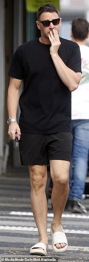 He teamed a pair of white slippers with a black T-shirt and shorts