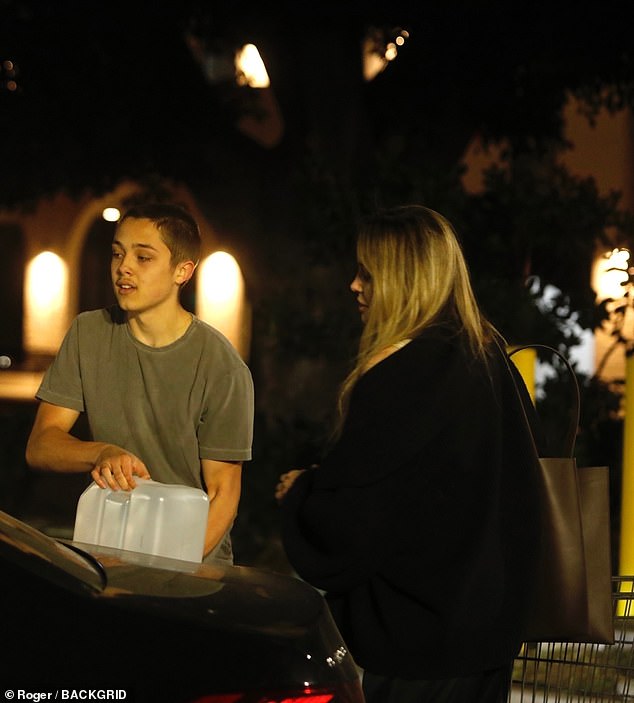 Knox was seen next to his mother as he loaded water into the car