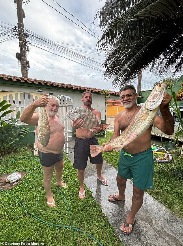 Paula Moreira's family shows off the fish they bought on a local beach for a family meal