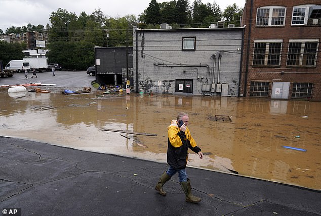 A man walks past a flooded area near the Swannanoa River. Asheville, NC, September 27, 2024