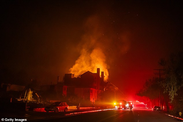 Flames from the Palisades Fire burn through a residential building on Sunset Boulevard amid a powerful storm on January 9, in the Pacific Palisades neighborhood of Los Angeles