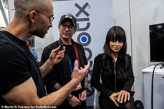 Above is the robot Melody (far right) with its founder Martin McMullen (middle). Melody is a sitting version of the robot