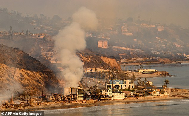 In this aerial view taken from a helicopter, homes burn on the Pacific Coast Highway during the Palisades fire in Malibu on Thursday. Redick and his family rented a house in the area