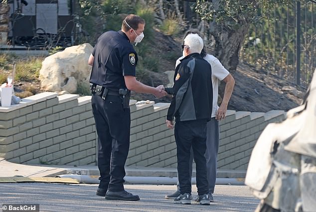 At one point, Woods was joined on the street by other individuals – including a police officer – and they had a conversation while standing next to a burned-out vehicle.