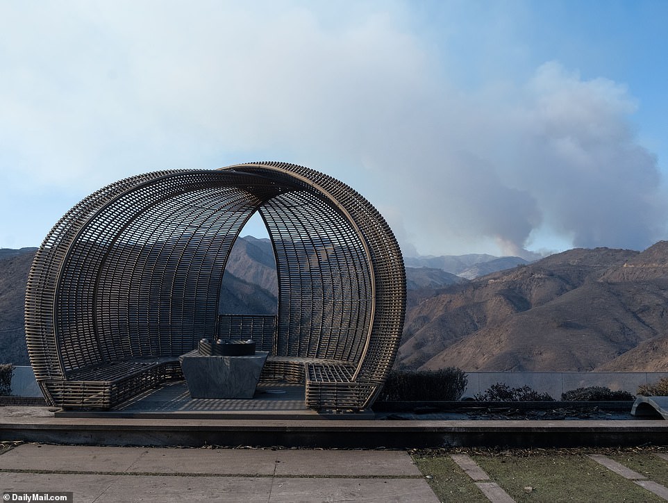 Although the famous fire pit with its elaborate rattan bench remains intact, it has become black with soot, while the once breathtaking views of the hills are now a wasteland of charred chapparal.