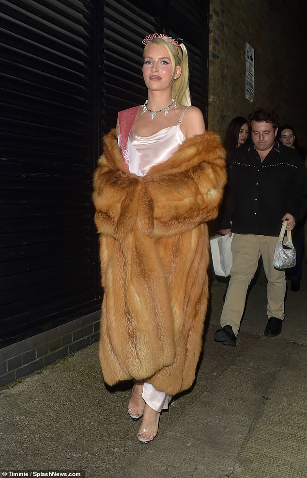 Lottie showed off her incredible figure in a pale pink satin dress and boosted her height in platform heels