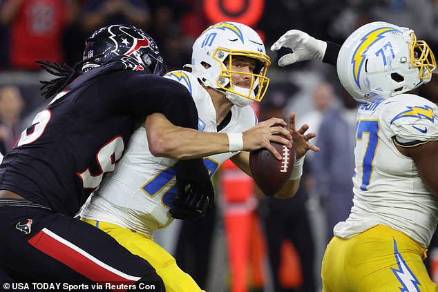 Justin Herbert (10) is sacked by Denico Autry (96) in the third quarter on Saturday.