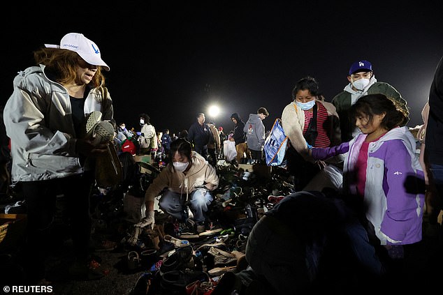 People search for shoes at a distribution center for people affected by the Eaton fire at Santa Anita Park in Arcadia, California