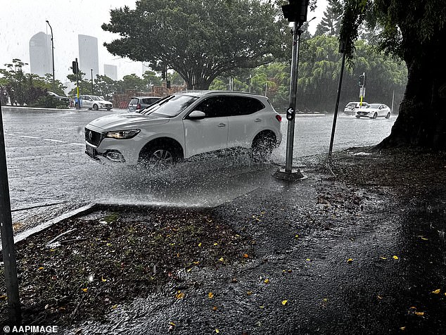 Queensland has borne the brunt of the wild weather in recent days. A car is pictured driving through large puddles due to heavy rain in Brisbane on Saturday