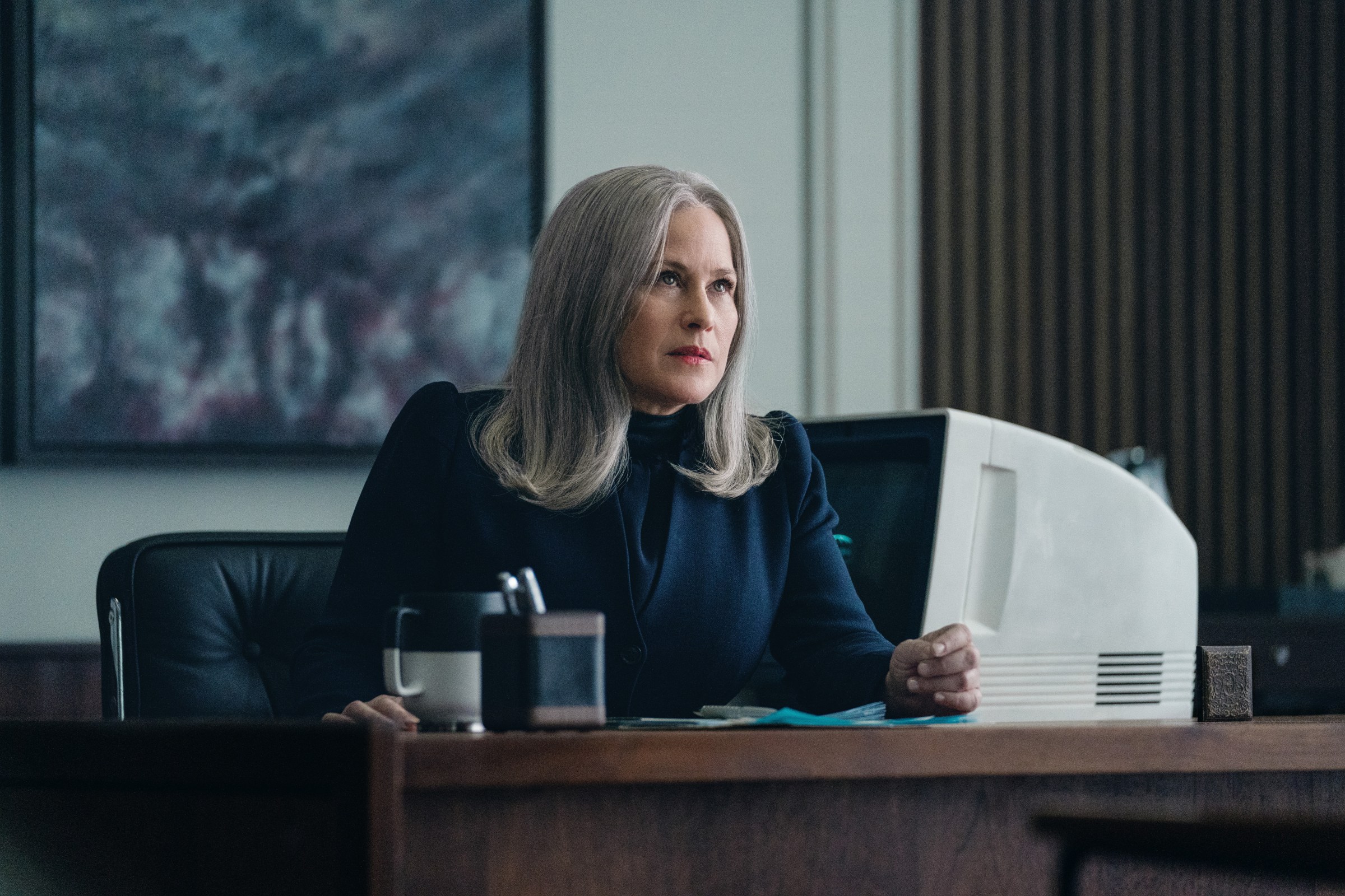 Patricia Arquette sits at a desk in Severance