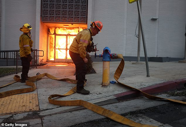 Los Angeles County firefighters unsuccessfully try to get water from a fire hydrant as they battle the Eaton fire